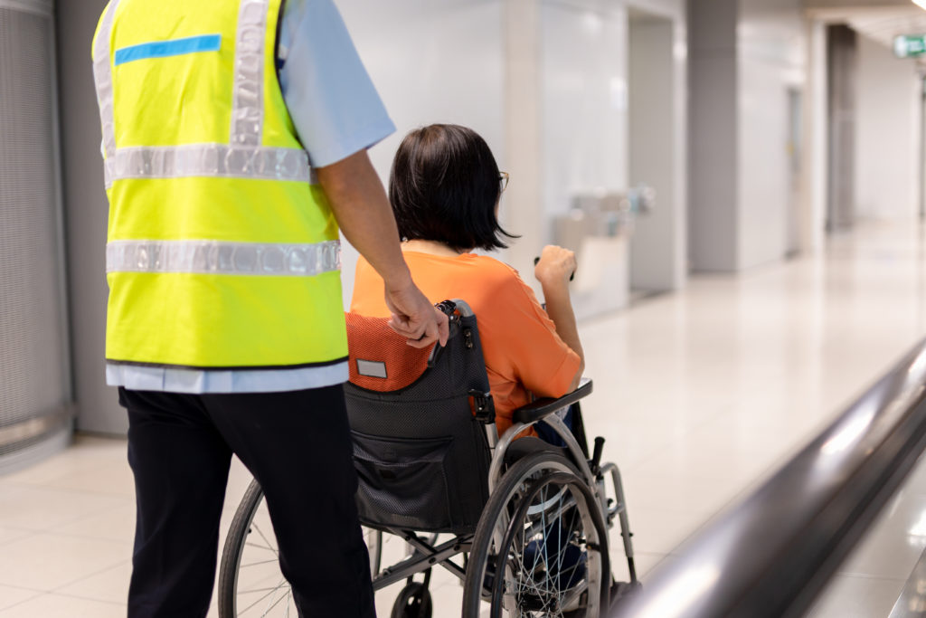 man-pushes-person-in-wheelchair